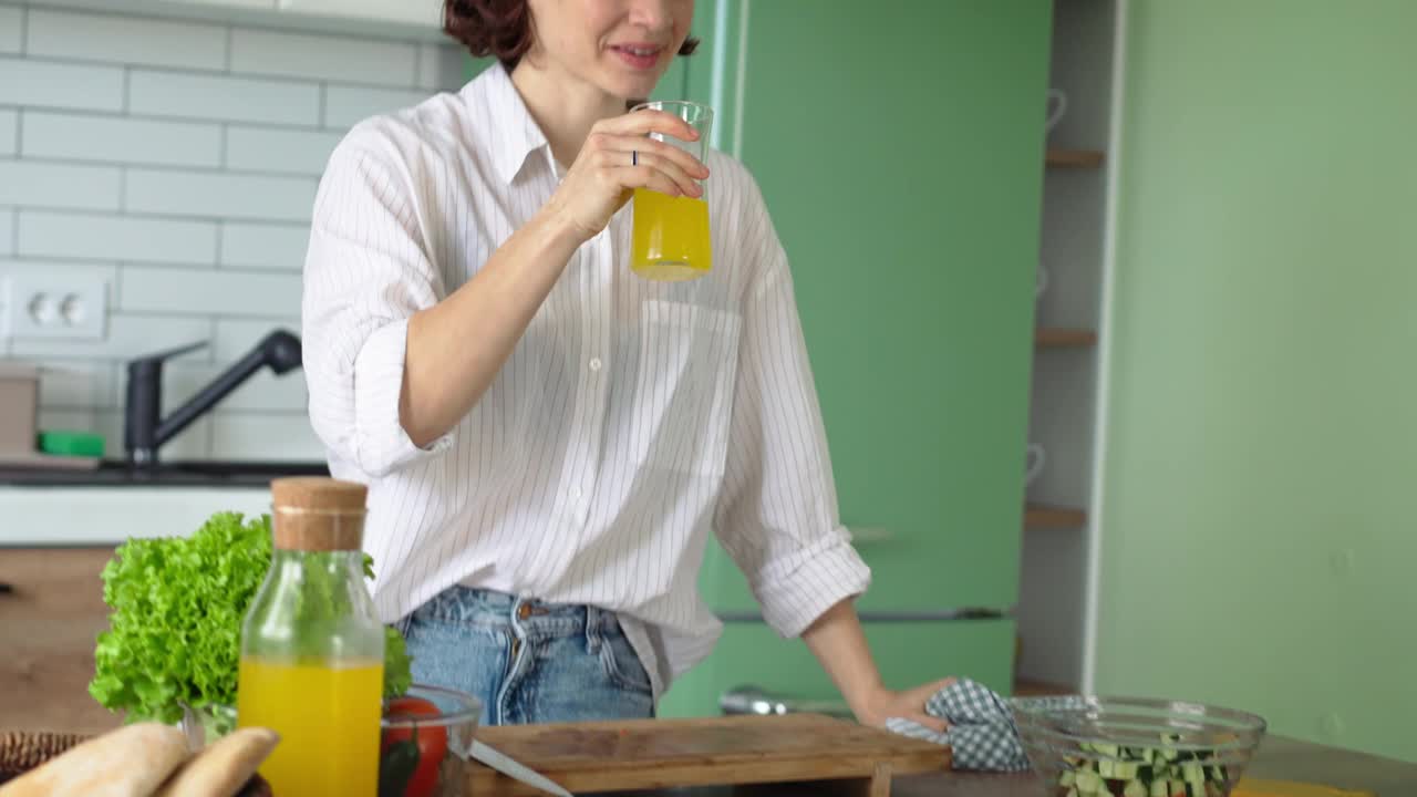 一个年轻的白人妇女喝橙汁视频下载