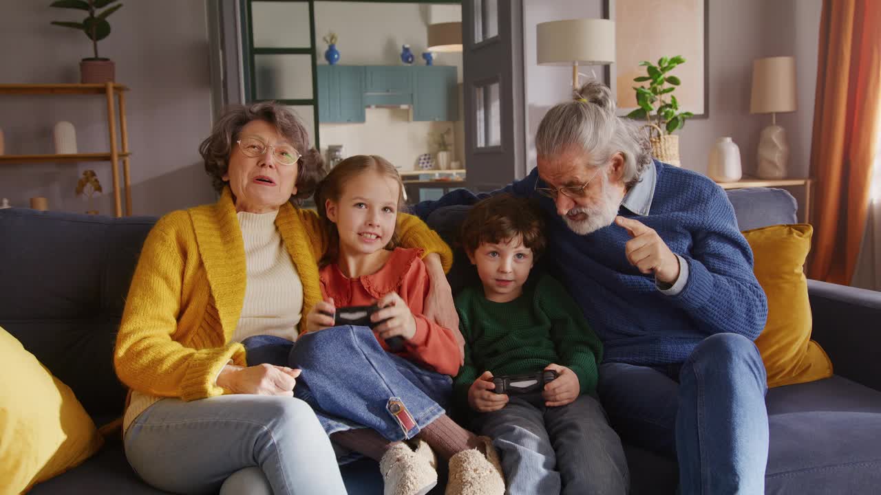 老夫妇照看孩子，用游戏机玩得开心视频下载