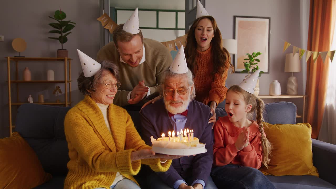 过生日的男人在女人手里的手工蛋糕上吹蜡烛视频下载