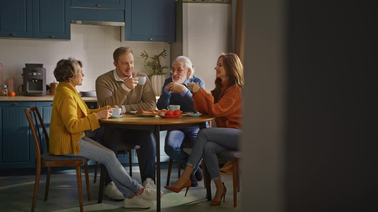 快乐的家庭享受早晨的咖啡和放松在厨房视频素材