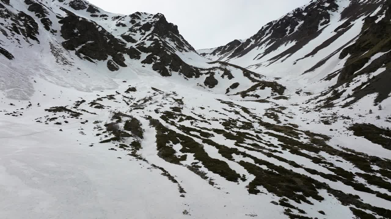 晚春自由骑行时，鸟瞰部分积雪覆盖的峡谷视频下载