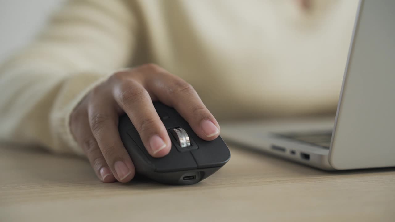 女人用手用笔记本电脑点击黑色的电脑鼠标视频下载