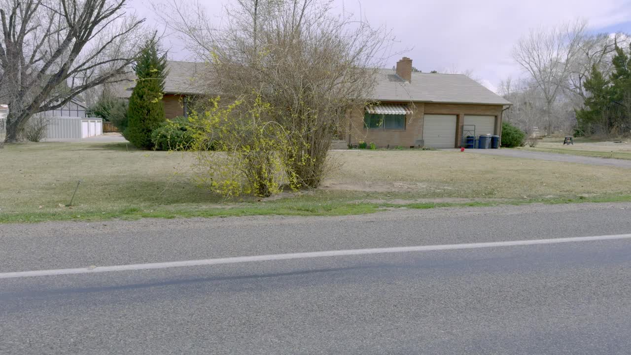 驾车穿过科罗拉多州大结市一个绿树成荫的大房子社区的侧视图视频下载