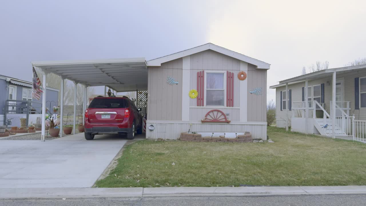 侧视图驾驶通过一个移动家庭附近的大房子在科罗拉多大交界处视频下载
