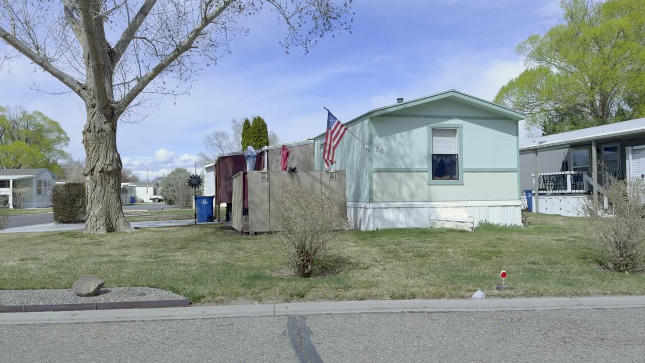 侧视图驾驶通过一个移动家庭附近的大房子在科罗拉多大交界处视频下载