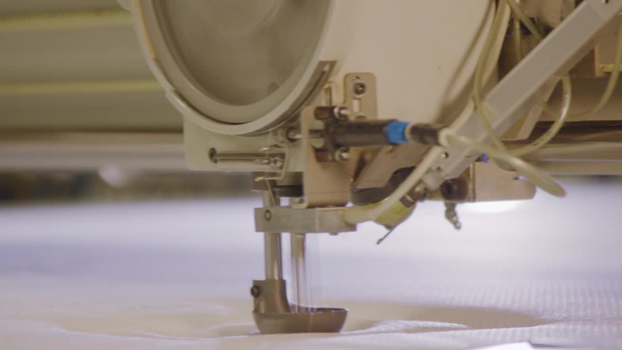 工业缝纫机缝制面料在弹簧床工厂，特写视频下载