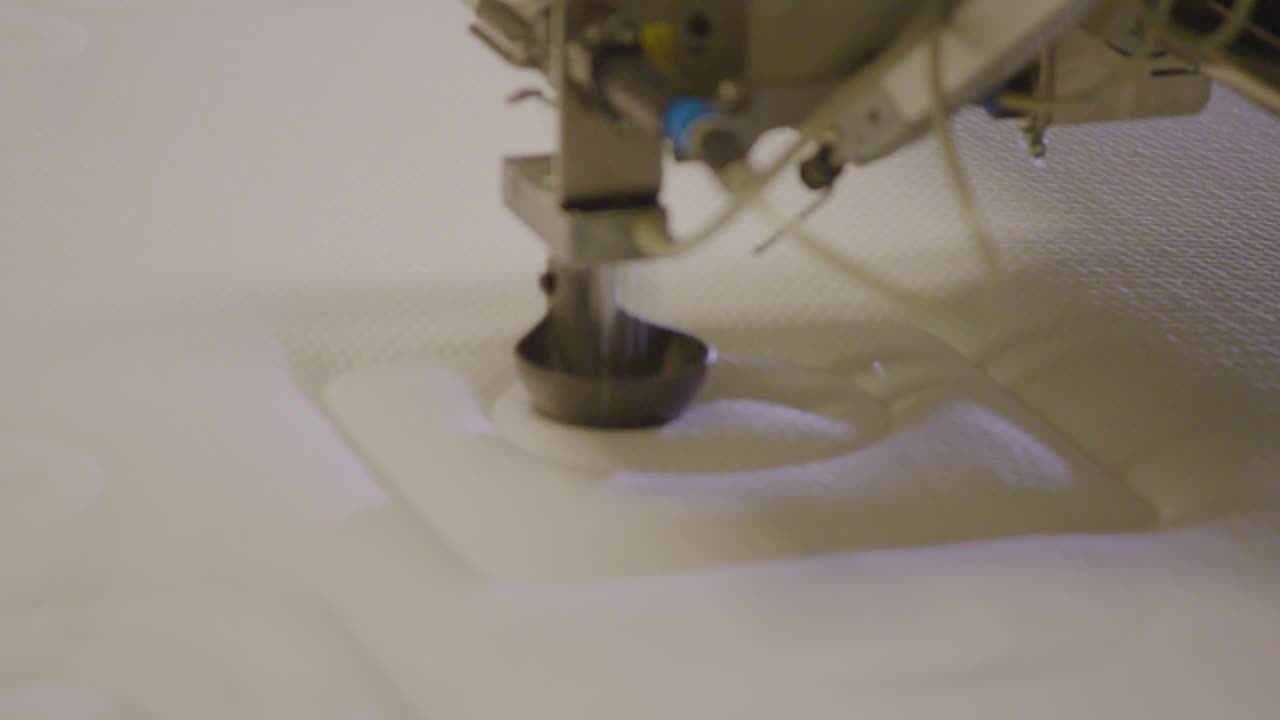 机器人手臂在工厂的床垫上缝制复杂的图案(特写)视频素材
