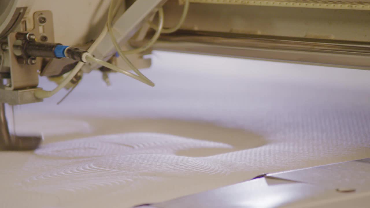 工业缝纫机在织物上缝制图案，弹簧床工厂的特写视频素材