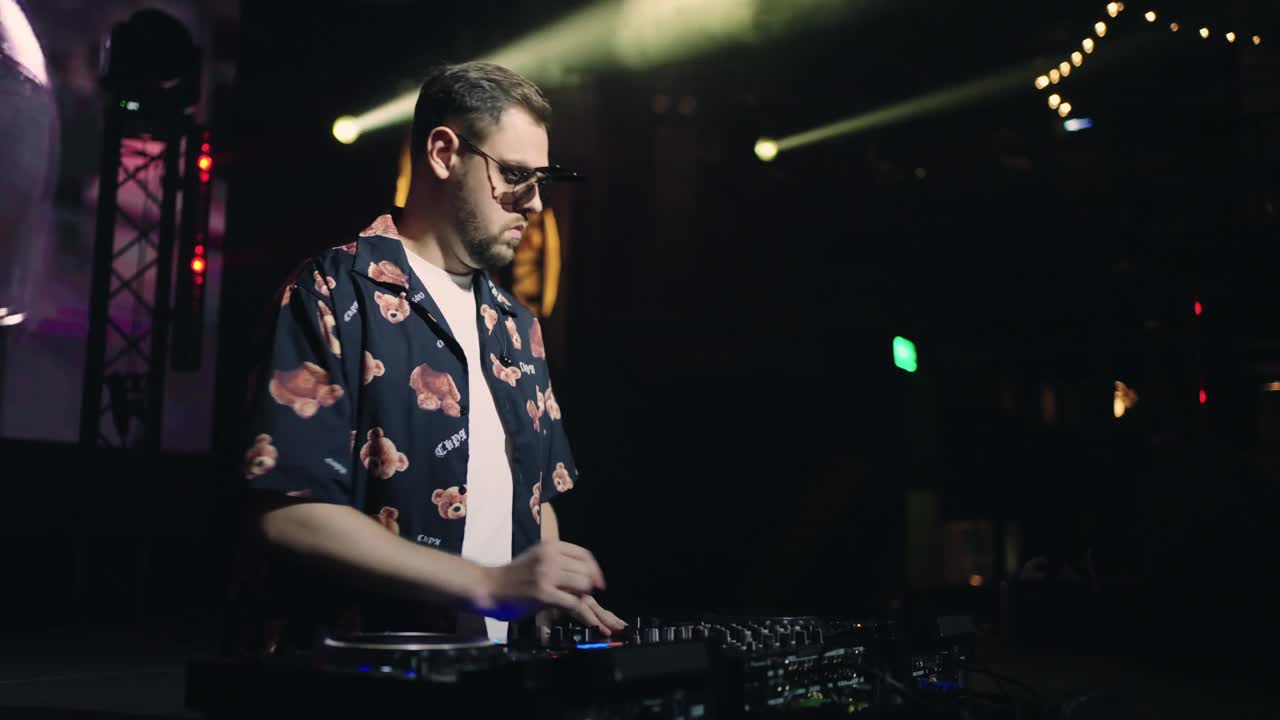 酷DJ男子在夜总会的肖像，当代科技音乐风格，男子创造新的音乐轨道视频下载