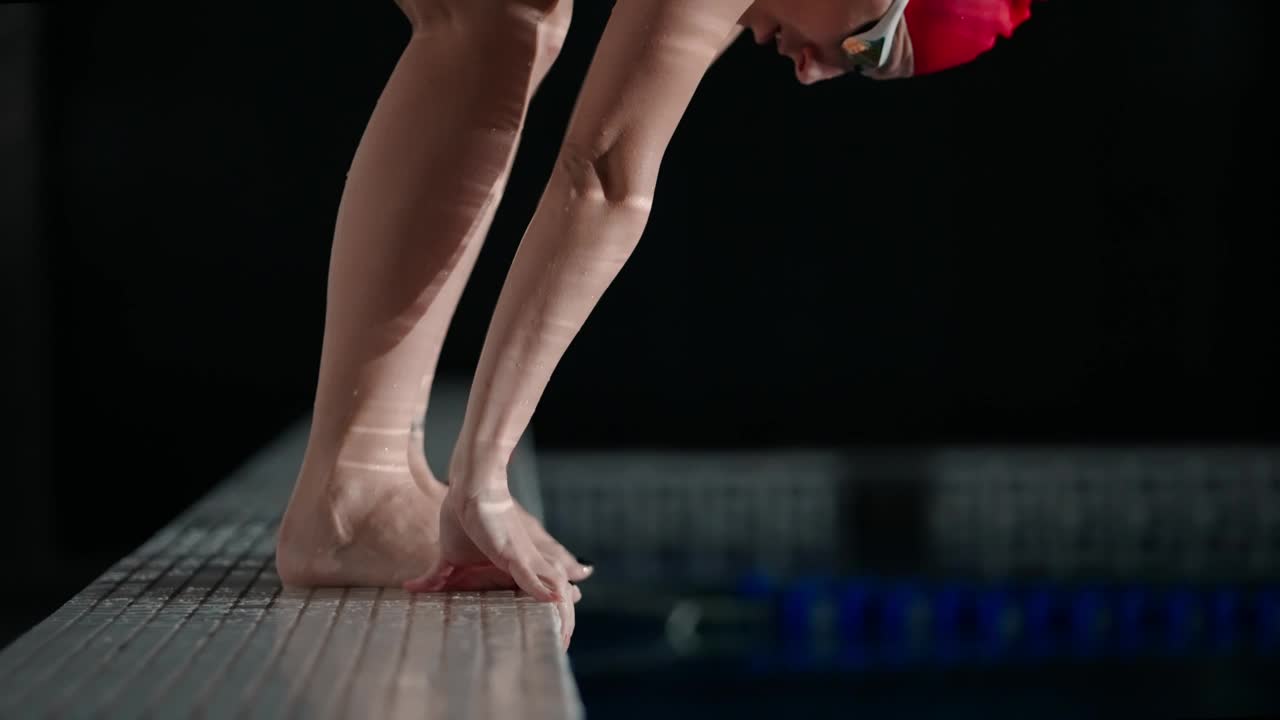 女运动员准备跳入水中，慢镜头，穿着红色泳装的女运动员视频下载