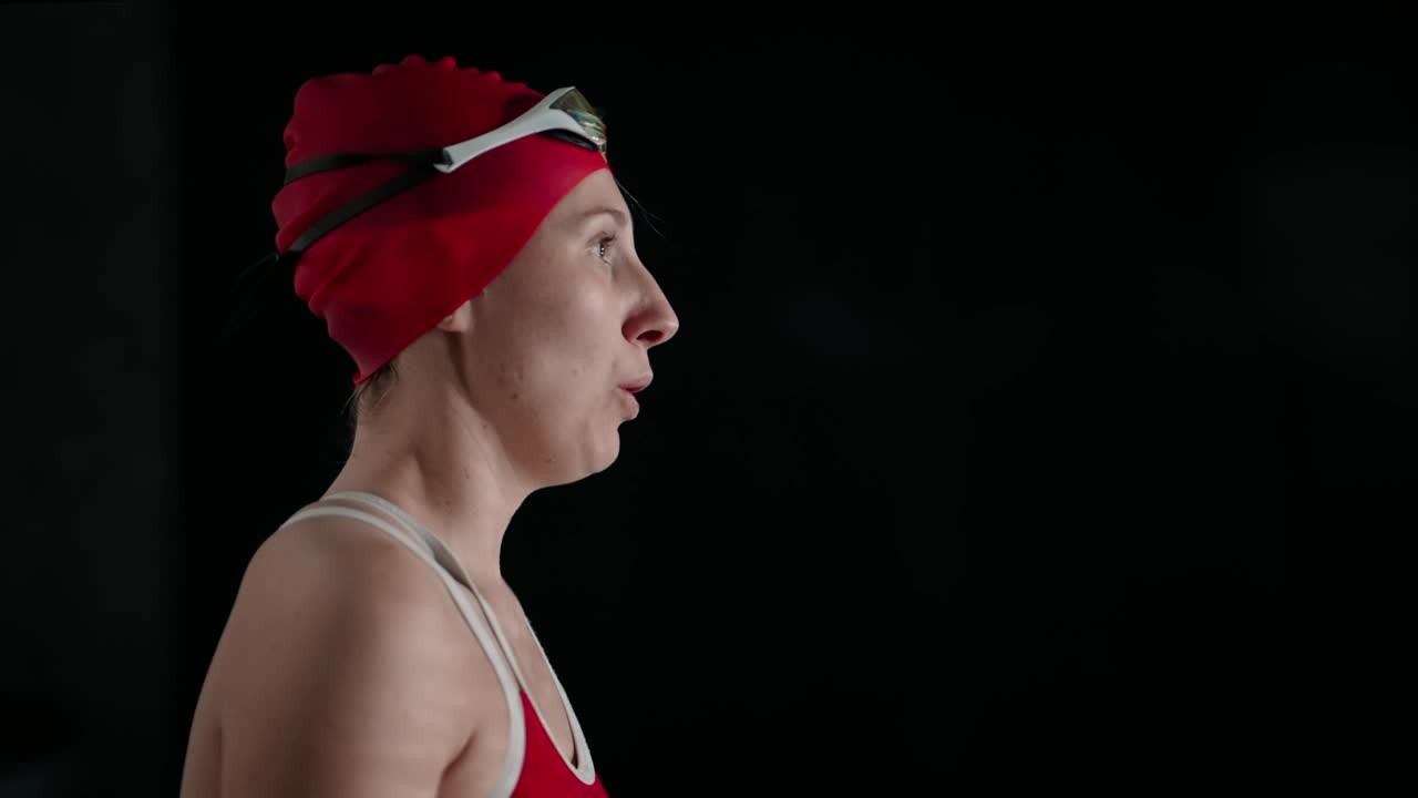 女子游泳运动员戴眼镜游泳，侧面肖像在游泳池拍摄视频下载
