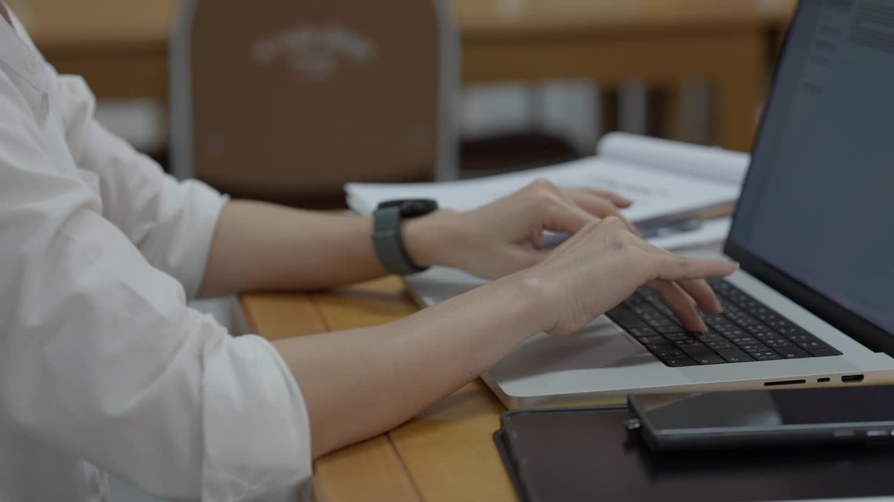在图书馆里用笔记本电脑工作的女人。视频下载