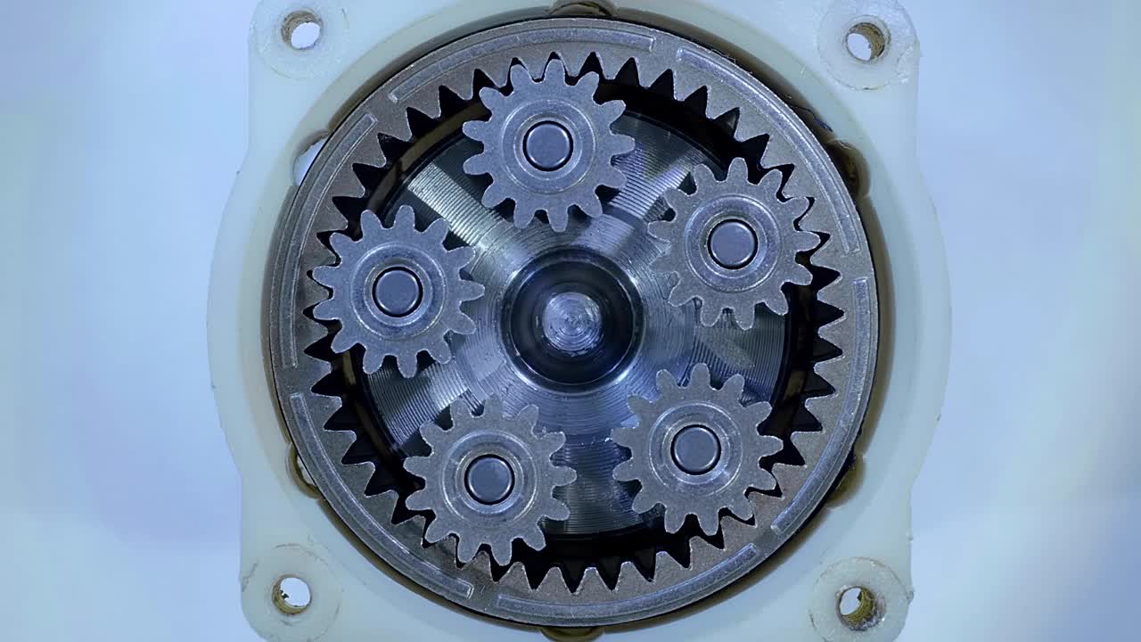 减速电机配有许多旋转的金属齿轮，在灯光下闪闪发光视频下载