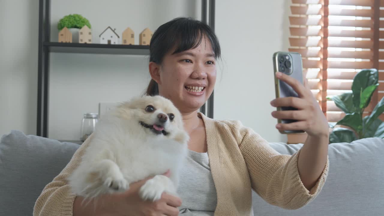 一个女人和她的狗享受用手机视频通话的快乐时刻视频下载