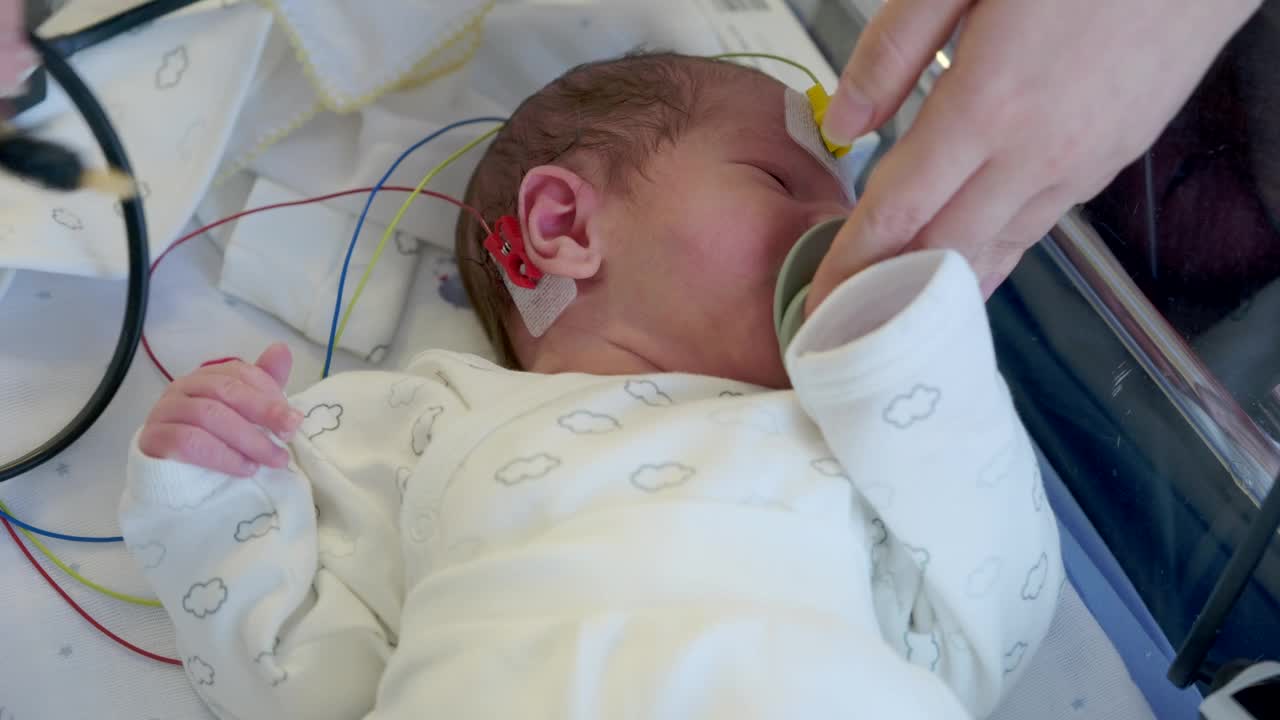新生儿听力筛查。在医院里，新生儿接受听力测试。视频下载