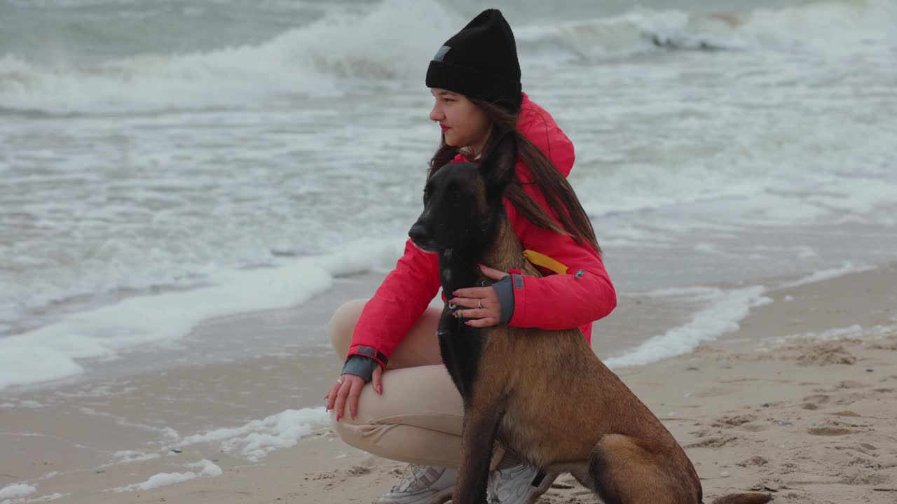 一个女人和她的狗坐在海边视频下载