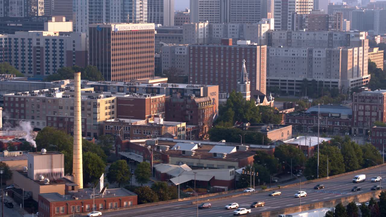 阳光明媚的亚特兰大市中心的工厂和办公楼。市中心连接器在前景。航拍镜头与下降摄影机运动视频下载