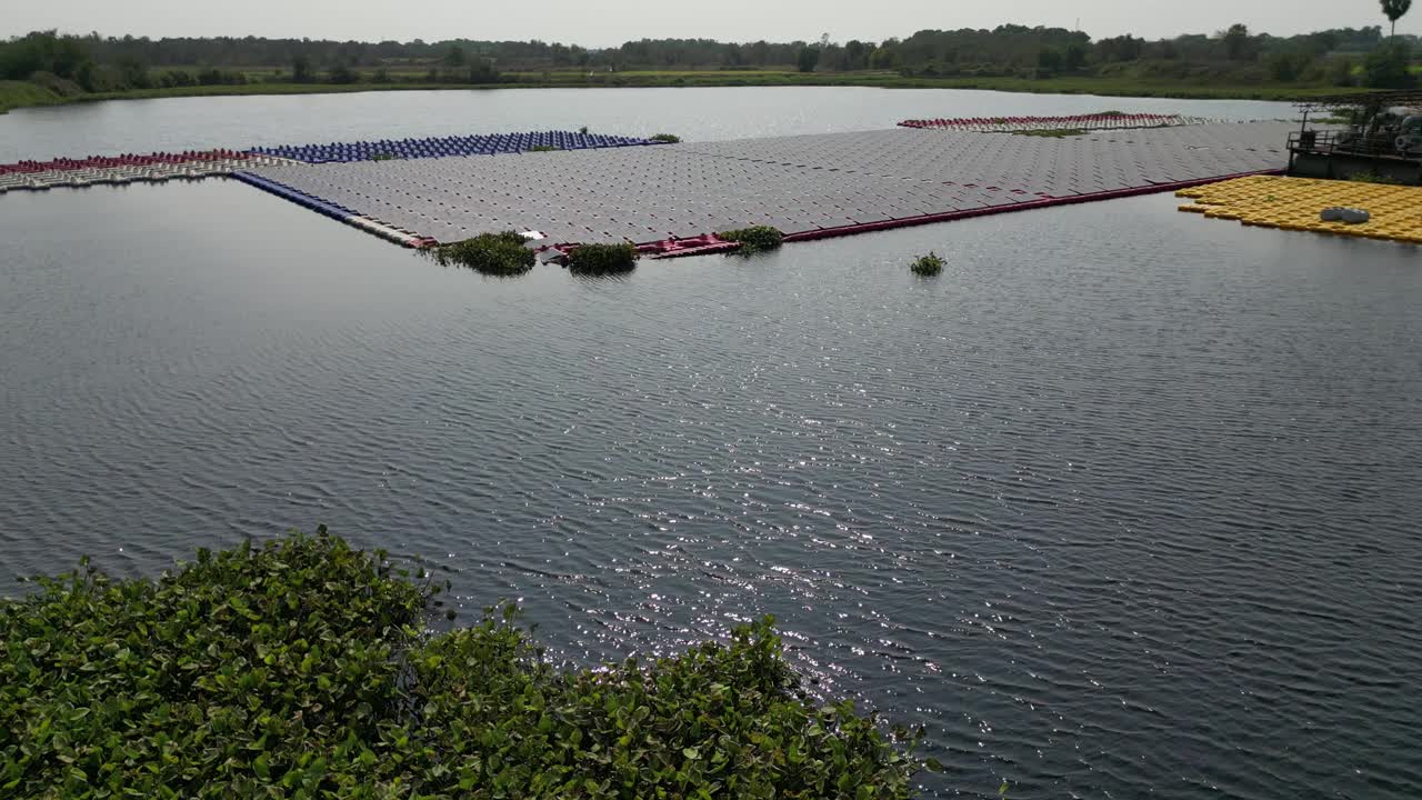 漂浮在水面上的太阳能电池板和电池平台。浮动太阳能或浮动光伏(FPV)。鸟瞰图。太阳能电站排阵列的水上安装系统安装在湖中。视频下载