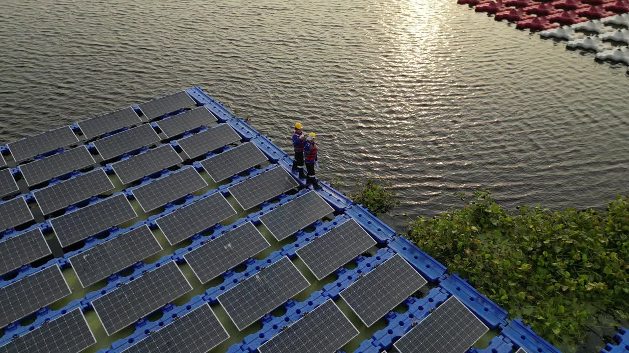 男工人正在修理水上漂浮的太阳能电池板。工程师在现场建造浮动太阳能电池板。未来生活的清洁能源。工业可再生能源的绿色动力。视频下载