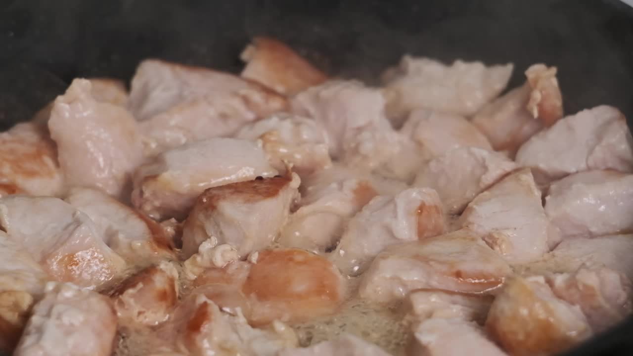 鸡块在家庭厨房的煎锅里用慢动作煎视频下载