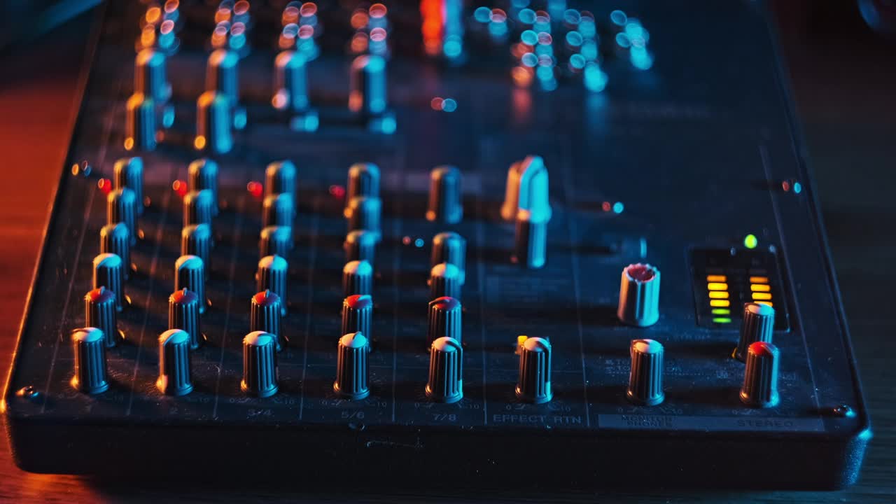 音响工程师在霓虹灯特写中移动音频混音控制台的调频器水平视频下载