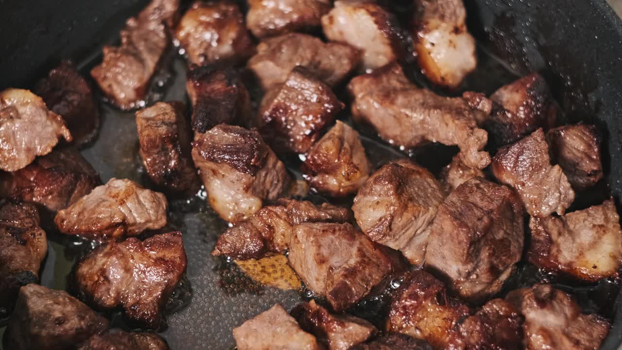在家庭厨房的煎锅里煎猪肉(特写)视频下载