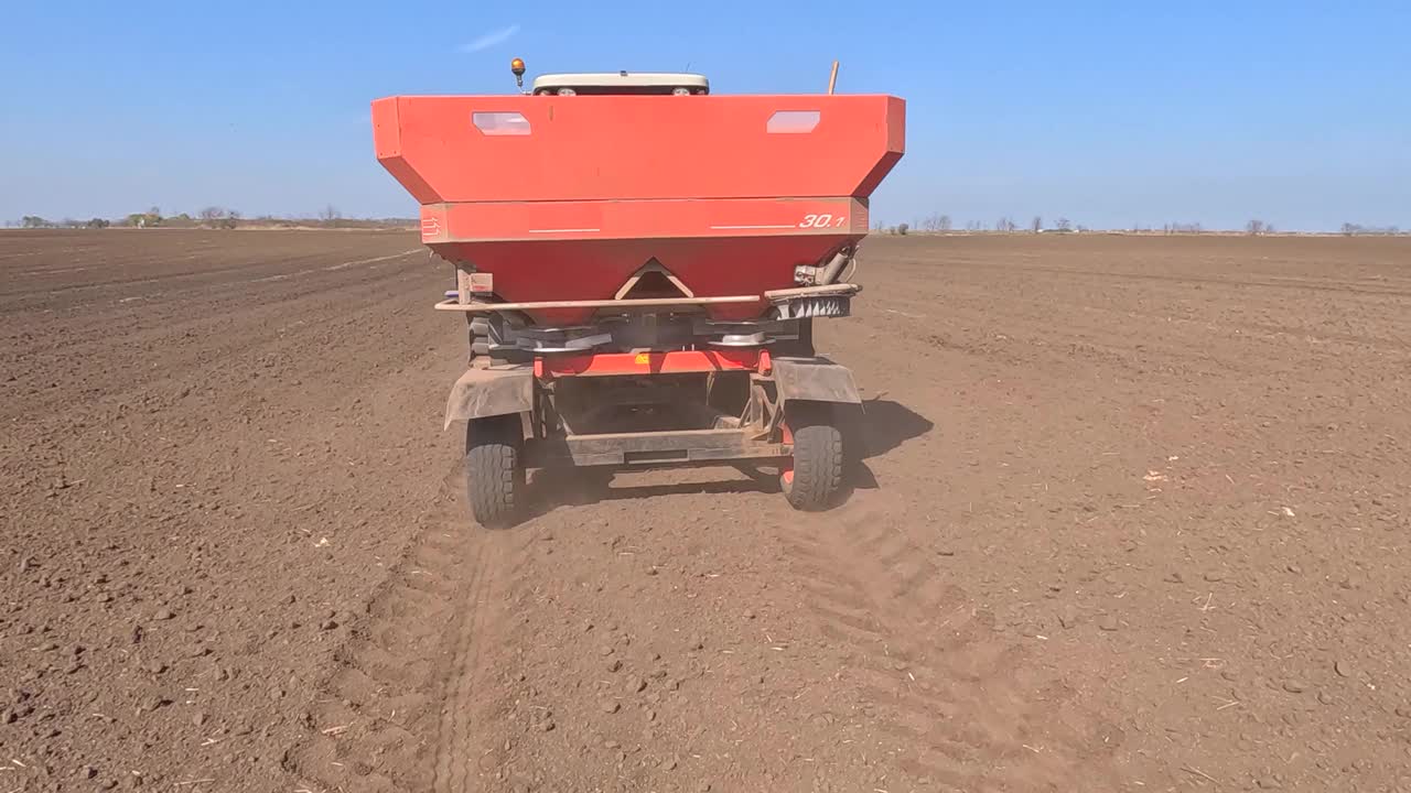 拖拉机和播种机在耕地上施肥，慢镜头视频下载