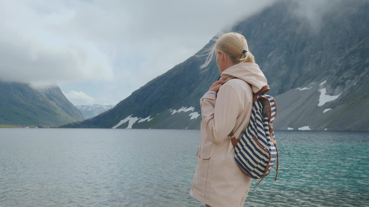 一个女人看着挪威的一个高海拔湖泊，隐遁而逃离了整个概念视频下载