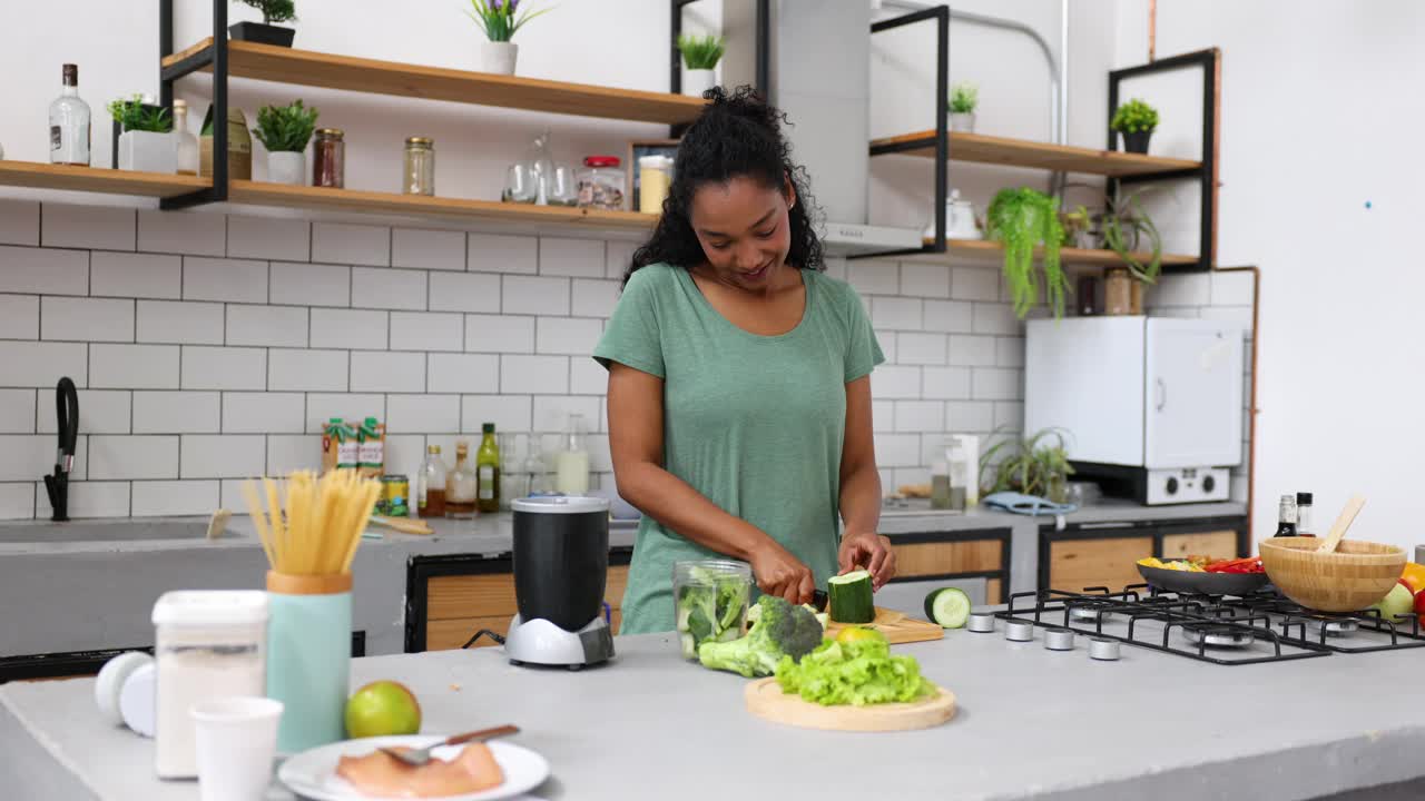 非裔美国妇女在家里切蔬菜做绿色奶昔视频下载