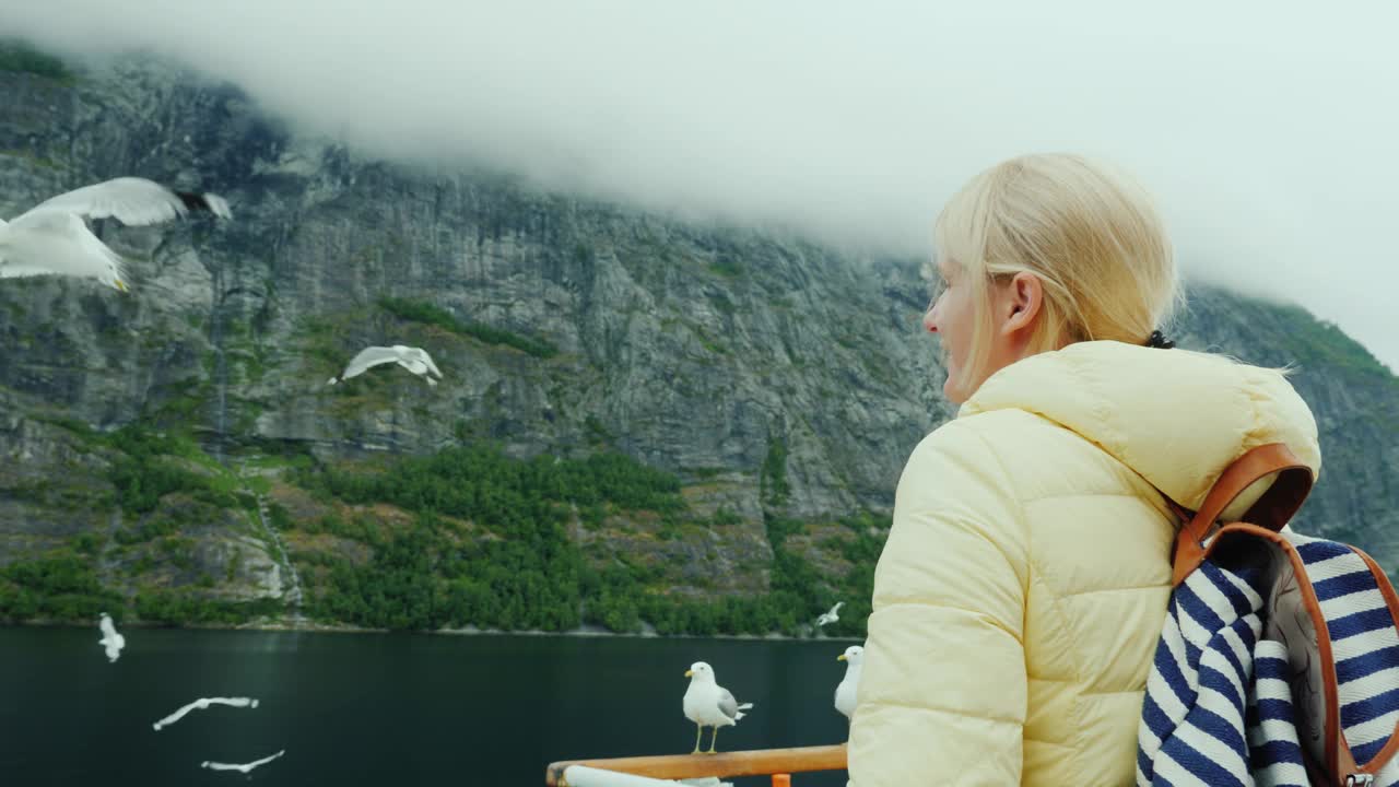 一位女士在游轮上欣赏美丽的挪威峡湾视频下载