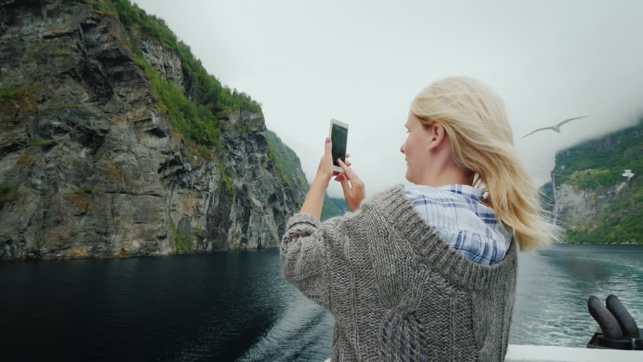 一名游船乘客在挪威峡湾拍摄海鸥和美丽风景的照片视频下载