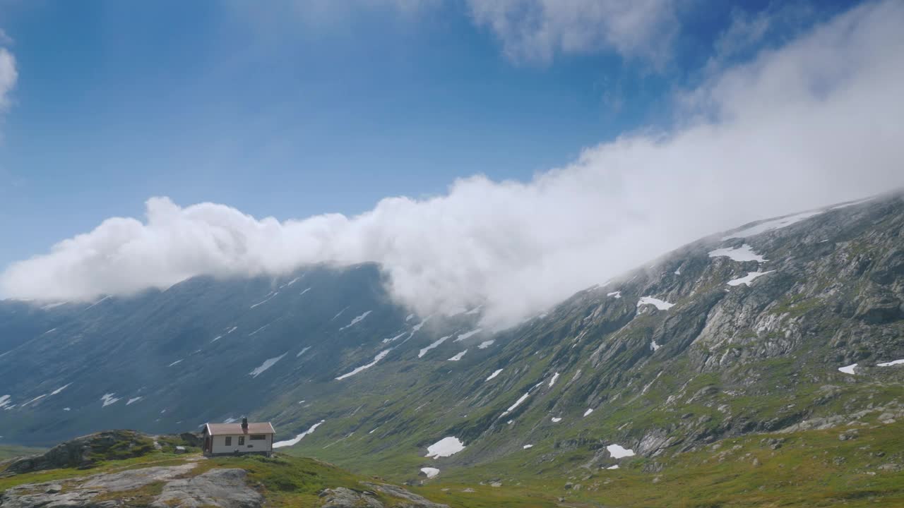 在挪威风景如画的山区附近骑行，驶过一座孤零零的木屋。车窗外的风景视频下载