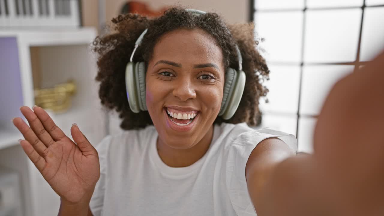戴着耳机的非裔美国妇女在室内自拍视频下载