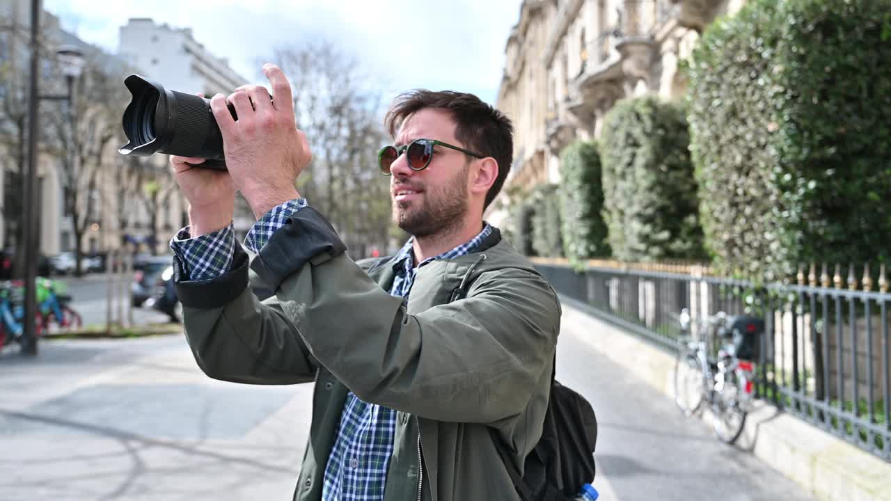 男性独自游览城市。一个人戴着墨镜在著名的街道上拍照视频下载