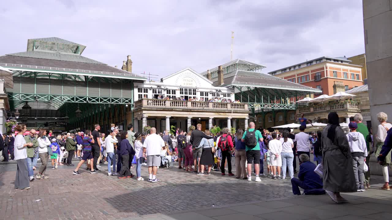 伦敦游客在市场大厦前的考文特花园广场观看表演视频下载