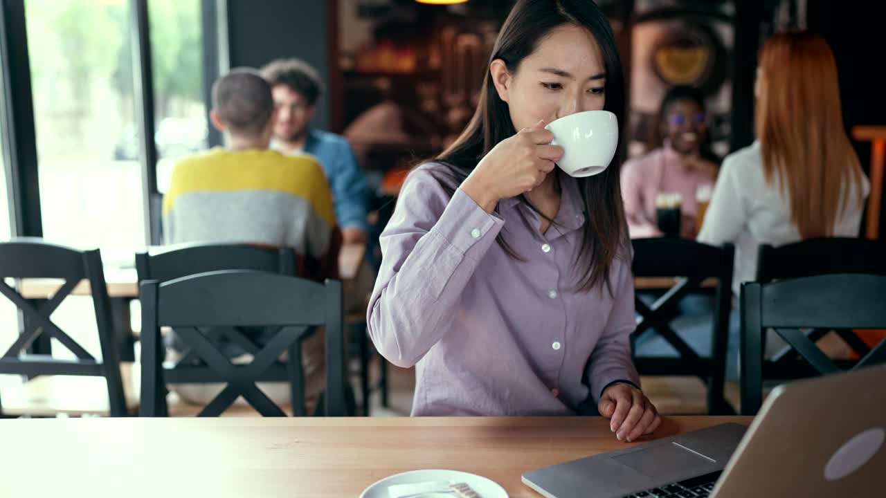 女商人在咖啡馆使用笔记本电脑视频下载
