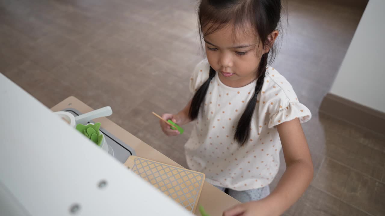 小女孩在玩厨房玩具，用木刀切食材视频下载