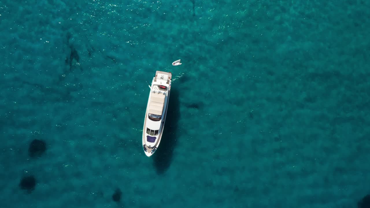 空中豪华摩托艇停泊在海湾与清澈，蓝色的水视频下载
