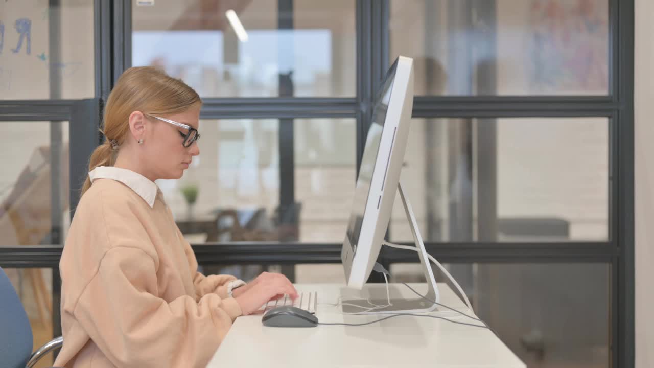 咳嗽的年轻女性在办公室使用桌面视频下载