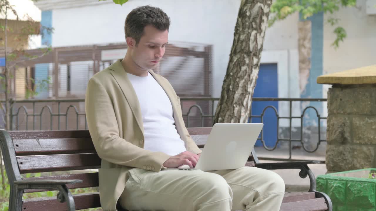 年轻人在使用手提电脑后离开户外长凳视频下载