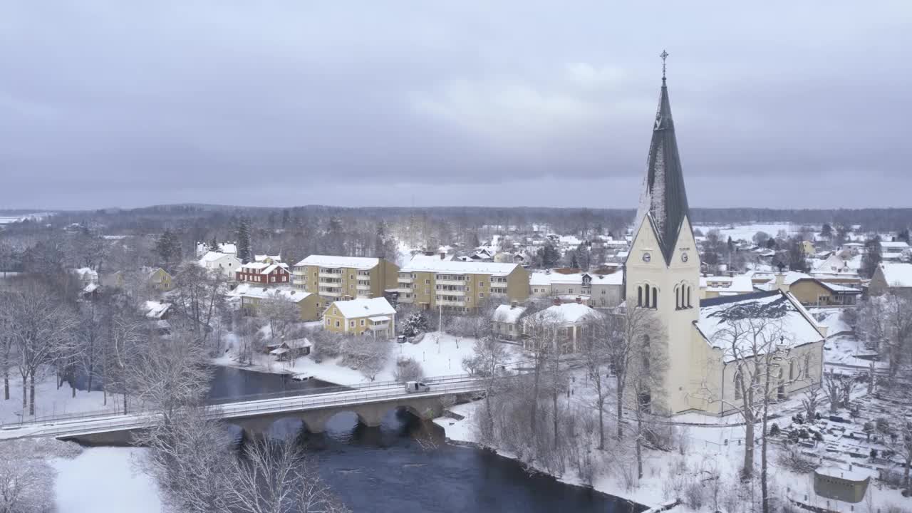 无人机盘旋，俯瞰河流、桥梁、教堂等，冬天的瑞典视频下载