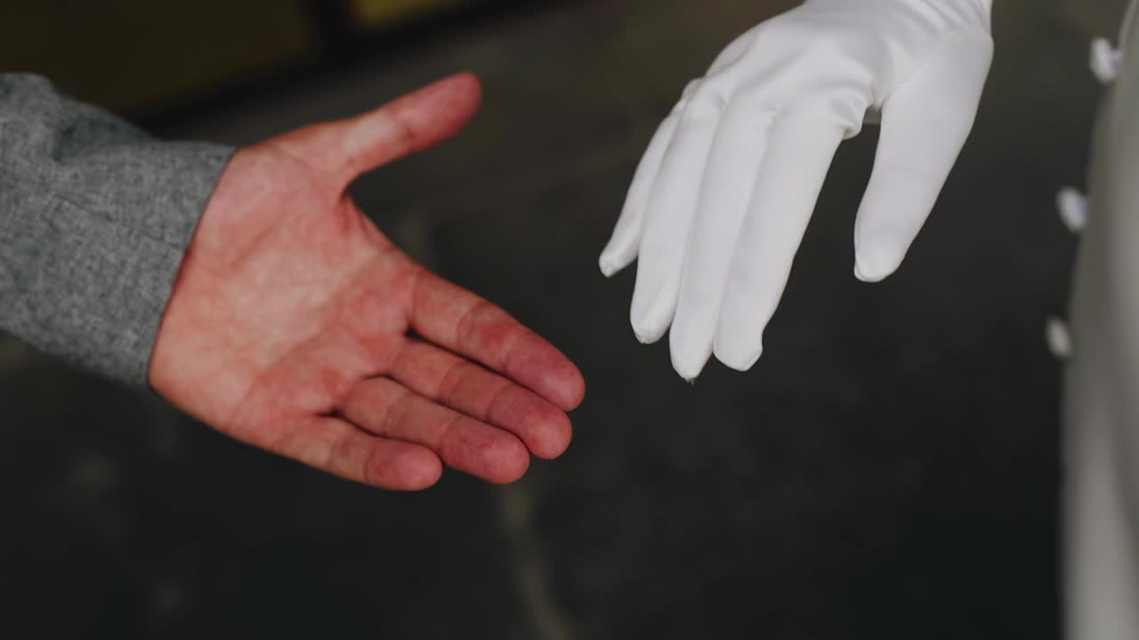 一个男人牵着他女朋友的手。她手上戴着一只漂亮的白色手套视频下载