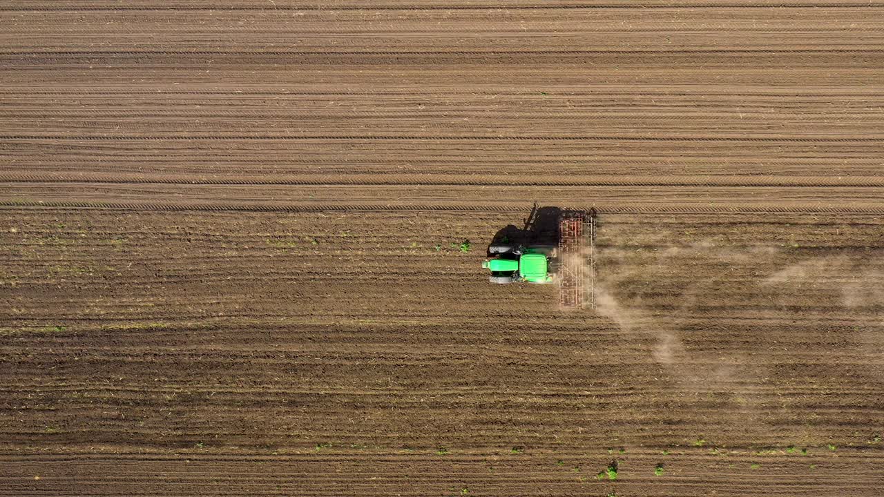 农用拖拉机附柄在田间进行土壤耕作的鸟瞰图视频下载