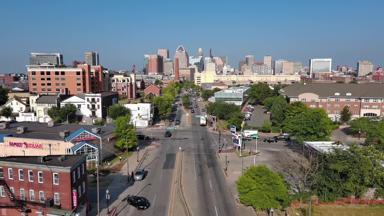 住宅区沿着马里兰州巴尔的摩市的总统街排列。凤凰射击塔和市中心的天际线显示在远处。航拍画面沿路向前上升视频下载