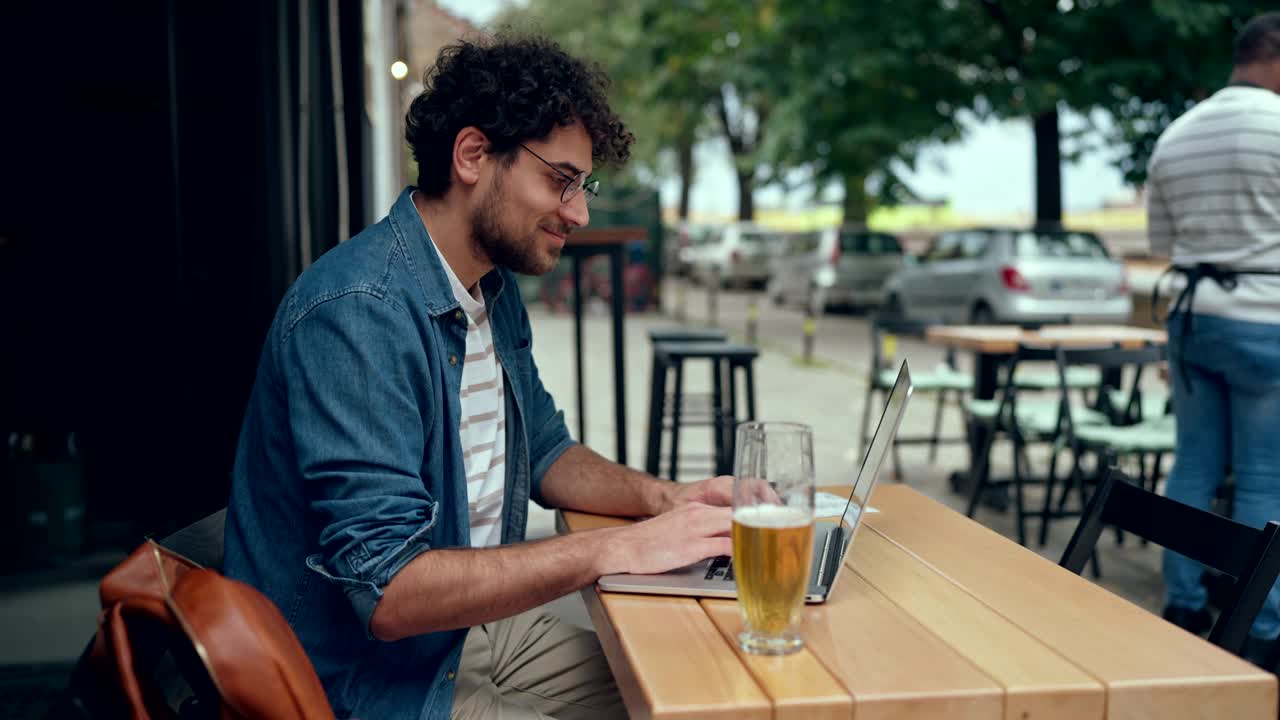 年轻人在咖啡馆使用笔记本电脑视频下载