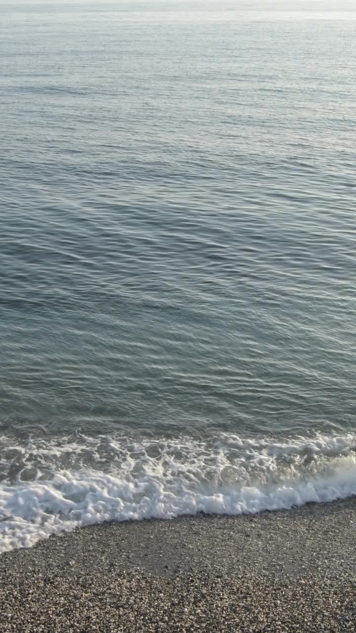 蓝色平静的海岸。4 k垂直视频下载