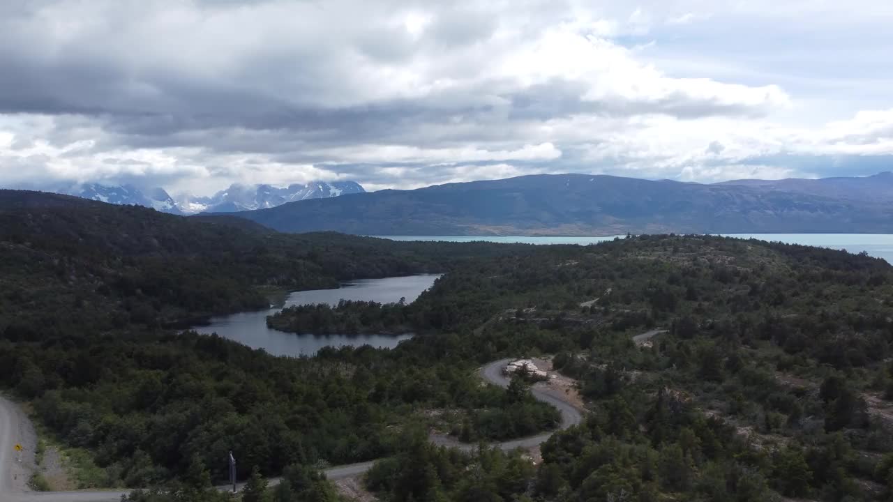 从远处望去，智利托雷斯德尔潘恩国家公园的湖泊和通往公园的道路映入眼帘视频下载