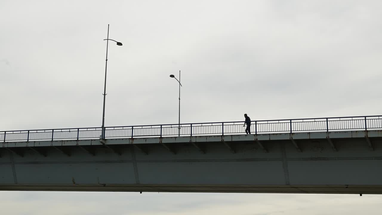 背光下一个成年男子过桥的剪影视频下载