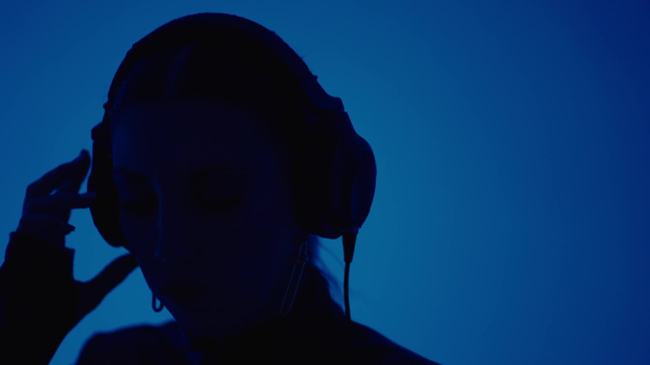 女DJ听音乐的耳机和混合轨道在夜总会，肖像附近的DJ混音器视频下载