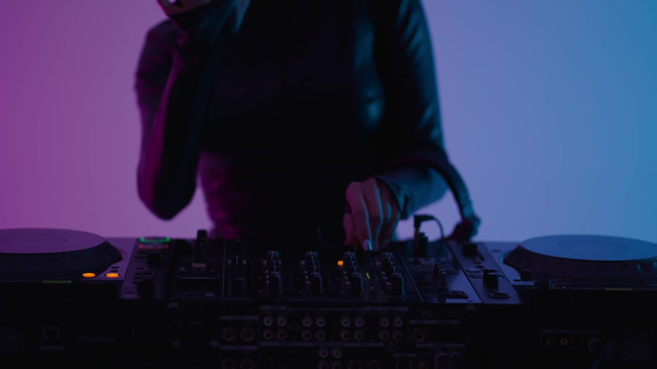 女DJ在夜总会，近景的现代DJ混音在舞池，科技狂欢派对视频下载